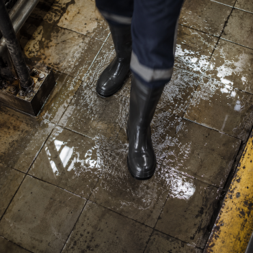 Safety boots on wet factory floor — Indcare safety footwear built for Indian industrial conditions